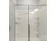 Modern shower with glass doors, shelving, and neutral colored tile at 2031 Killian Creek Dr, Denver, NC 28037