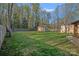 Spacious backyard featuring green grass, wooden privacy fence, and an outbuilding at 235 Stafford Estates Dr, Salisbury, NC 28146