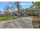 Beautiful stone home featuring a long driveway, manicured lawn, and mature trees at 235 Stafford Estates Dr, Salisbury, NC 28146