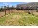 Large, fenced backyard featuring grass, decks, and mature trees, ideal for outdoor activities at 2557 Grantham Place Dr, Fort Mill, SC 29715
