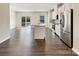 Open-concept kitchen with stainless steel appliances and island with bar seating flows into a spacious living area at 2557 Grantham Place Dr, Fort Mill, SC 29715