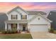 Charming two-story home with gray shutters, a covered porch, an attached garage and colorful twilight sky at 2893 Yeager Nw Dr, Concord, NC 28027
