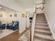 Inviting foyer with hardwood floors, staircase, adjacent room with a comfortable blue sofa, and homey decor at 2893 Yeager Nw Dr, Concord, NC 28027