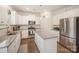 Bright kitchen with white cabinets, granite countertops, kitchen island, and stainless steel appliances at 2893 Yeager Nw Dr, Concord, NC 28027