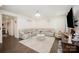 Open-concept living room with a large sectional sofa, wood floors, marble coffee table and elegant chandelier at 2893 Yeager Nw Dr, Concord, NC 28027