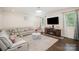 Bright living room with a large sectional sofa, TV and a marble-topped coffee table illuminated by recessed lighting at 2893 Yeager Nw Dr, Concord, NC 28027