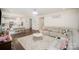 Open-concept living room with a large sectional sofa, dining area, wood floors and elegant chandelier at 2893 Yeager Nw Dr, Concord, NC 28027