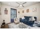 Cozy living room features a plush blue sofa, patterned rug, modern ceiling fan, and natural light at 2893 Yeager Nw Dr, Concord, NC 28027