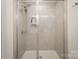 Modern shower with tile surround, rainfall shower head, and built-in shelving at 2893 Yeager Nw Dr, Concord, NC 28027