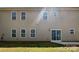 Rear exterior of the home featuring multiple windows and a sliding glass door to the backyard at 3026 S Devon St, Charlotte, NC 28213