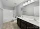 A bright bathroom with a double sink vanity, tiled floor, and a shower-tub combo, creating a functional and clean space at 3026 S Devon St, Charlotte, NC 28213