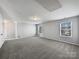 An expansive bonus room featuring plush carpet, neutral walls, and natural light through the large windows at 3026 S Devon St, Charlotte, NC 28213