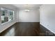 Well-lit dining area featuring hardwood floors, a stylish chandelier, and a large window providing ample natural light at 3026 S Devon St, Charlotte, NC 28213
