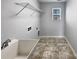 Bright laundry room with ample space, utility sink, overhead shelving, and a window at 3026 S Devon St, Charlotte, NC 28213