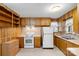 Compact kitchen with wooden cabinets, white appliances, and a vinyl floor at 304 Simrill Ave, York, SC 29745