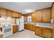 Kitchen featuring wooden cabinets, white appliances, and linoleum flooring at 304 Simrill Ave, York, SC 29745