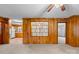 View of the living room and kitchen featuring wood paneled walls and neutral carpet at 304 Simrill Ave, York, SC 29745