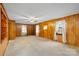 Living room with wood paneling, neutral carpet, and natural light from windows at 304 Simrill Ave, York, SC 29745