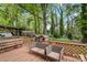 Wood deck with wicker chairs, bench seating, and a view of the wooded yard at 3612 Winterfield Pl, Charlotte, NC 28205