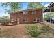 Backyard with two-story brick house, wood deck, shed, car port and a car at 3612 Winterfield Pl, Charlotte, NC 28205