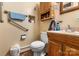 Standard bathroom with tan walls, wood cabinet, and accessibility bars near the toilet at 3612 Winterfield Pl, Charlotte, NC 28205