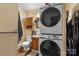 Bathroom with stacked washer and dryer, vanity and small wooden cabinet at 3612 Winterfield Pl, Charlotte, NC 28205