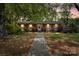 Charming single-story brick home with a welcoming walkway and lush landscaping, set against a backdrop of mature trees at 3612 Winterfield Pl, Charlotte, NC 28205