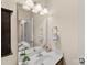 This bathroom has a mirrored vanity with a sink and chrome faucet under a three light fixture at 4528 Craigmoss Ln, Charlotte, NC 28278