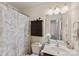 This bathroom features a shower with a patterned curtain, a wall cabinet, and a mirrored vanity at 4528 Craigmoss Ln, Charlotte, NC 28278