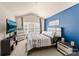 Bright bedroom with carpeted floors, a blue accent wall and ample natural light from the window at 4528 Craigmoss Ln, Charlotte, NC 28278