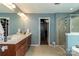 Bathroom featuring a double vanity, large mirror and tiled shower with glass doors at 4924 Riverdale Dr, Charlotte, NC 28273