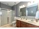 Bathroom featuring a double vanity, large mirror and tiled shower with glass doors at 4924 Riverdale Dr, Charlotte, NC 28273