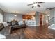 Open-concept living area with hardwood floors, kitchen access, and comfortable leather sectional sofa at 4924 Riverdale Dr, Charlotte, NC 28273