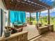 Inviting outdoor patio with pergola, stone features, and comfortable wicker furniture and drapes at 4924 Riverdale Dr, Charlotte, NC 28273