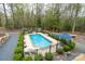 Scenic aerial view of the pool and cabin, showcasing the private backyard oasis and mature trees at 528 Manchester Rd, Mount Gilead, NC 27306