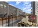 View from a townhouse balcony featuring black iron railings, planted containers, and townhome exteriors under a partly cloudy sky at 532 Billingsley Rd, Charlotte, NC 28211