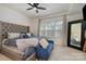 Comfortable main bedroom with a tufted headboard, bench, large windows, and ample natural light at 532 Billingsley Rd, Charlotte, NC 28211