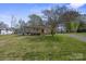 Charming home with covered porch, lush green lawn, and mature trees on a sunny day at 61 Brown Sw St, Concord, NC 28027