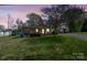 Charming home exterior with covered porch, nestled in a lush green lawn at twilight at 61 Brown Sw St, Concord, NC 28027