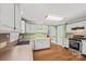 Traditional kitchen featuring white cabinets, wood flooring, and updated appliances at 61 Brown Sw St, Concord, NC 28027