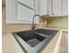 Close up of a kitchen sink with matte black faucet and neutral countertops and cabinets at 61 Brown Sw St, Concord, NC 28027