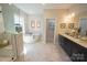 Bright bathroom featuring a soaking tub, dual vanities, and marble tile flooring for a luxurious experience at 7113 Fowley Rd # 0336, Charlotte, NC 28269