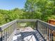 Charming balcony setting with outdoor table and chairs, surrounded by lush green trees and blue sky at 753 Mountainwater Dr, Charlotte, NC 28262