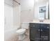 Bright bathroom featuring a shower-tub combo, and a vanity with a dark cabinet at 753 Mountainwater Dr, Charlotte, NC 28262