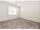 Bright bedroom with neutral carpet, ceiling fan, and a large window for natural light at 753 Mountainwater Dr, Charlotte, NC 28262