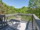 The outdoor deck has a table, chairs, gray railings, and a scenic view of mature trees at 753 Mountainwater Dr, Charlotte, NC 28262