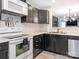 Kitchen featuring black cabinets, white appliances, stainless steel sink with view into connected room at 753 Mountainwater Dr, Charlotte, NC 28262
