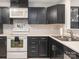 A kitchen with black cabinets, white countertop, stainless steel sink and appliances at 753 Mountainwater Dr, Charlotte, NC 28262