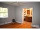 Bedroom with hardwood floors, ceiling fan, and adjacent bathroom with granite countertops at 8608 Cedarbrook Dr, Charlotte, NC 28215