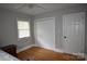 This bedroom includes a closet and a door and also features hardwood floors and natural light from a window at 8608 Cedarbrook Dr, Charlotte, NC 28215
